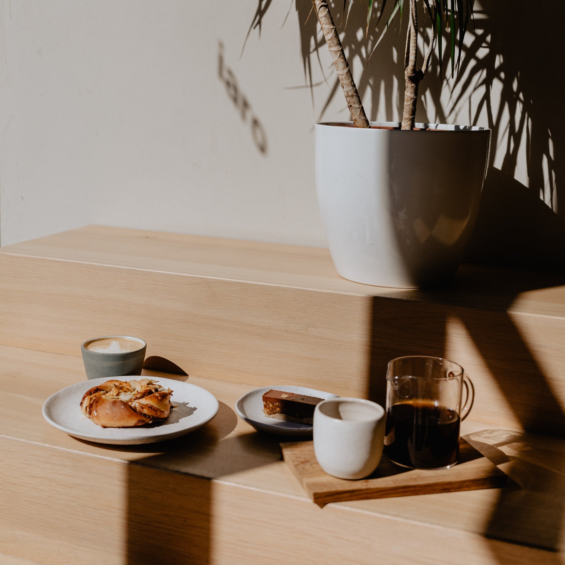 An atmospheric shot of a blue-grey iaro mug next to different food and coffee related props