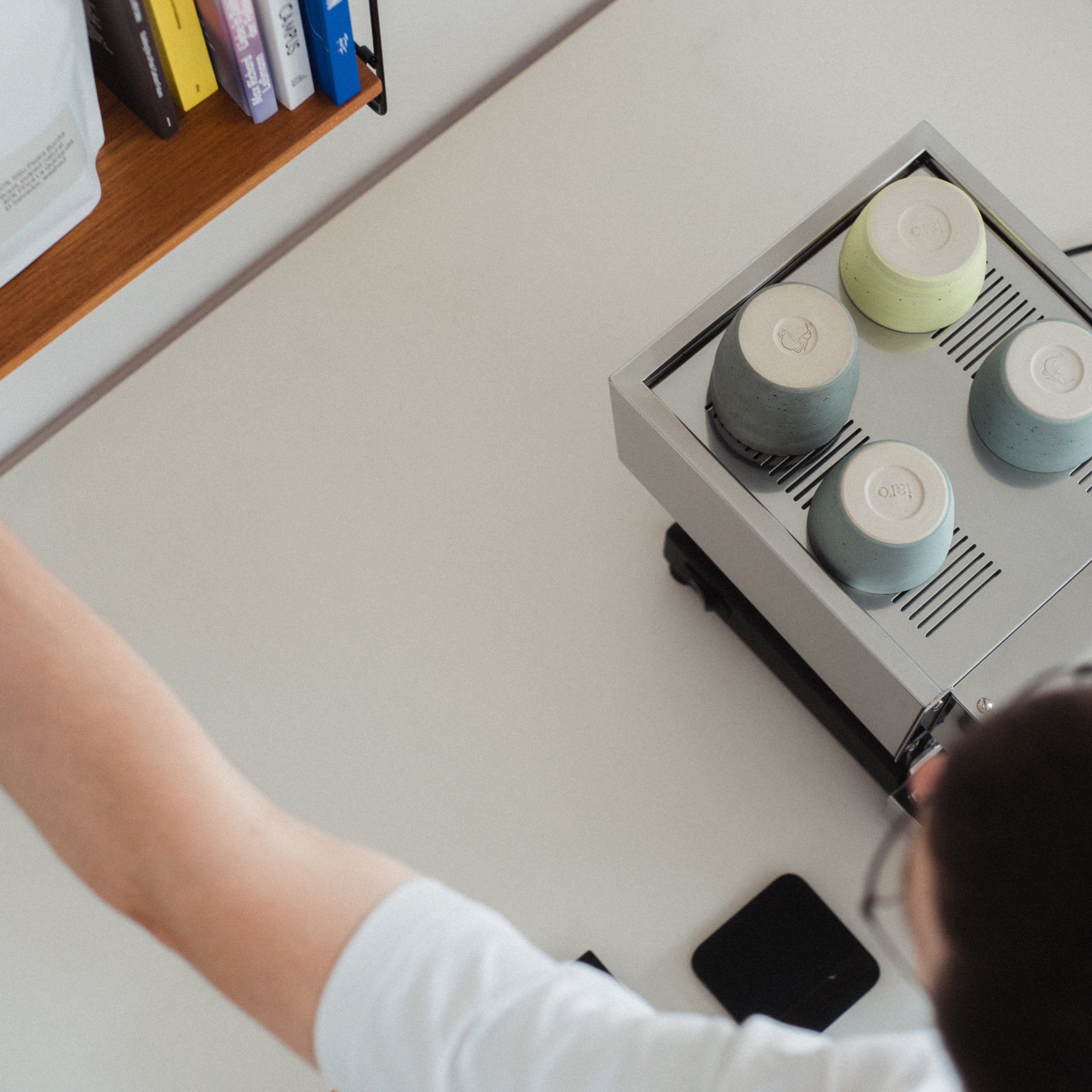 The home barista is reaching for a bag of specialty coffee from his shelve in order to prepare espresso with his la Marzocco linea Micra (also visible in the backround)