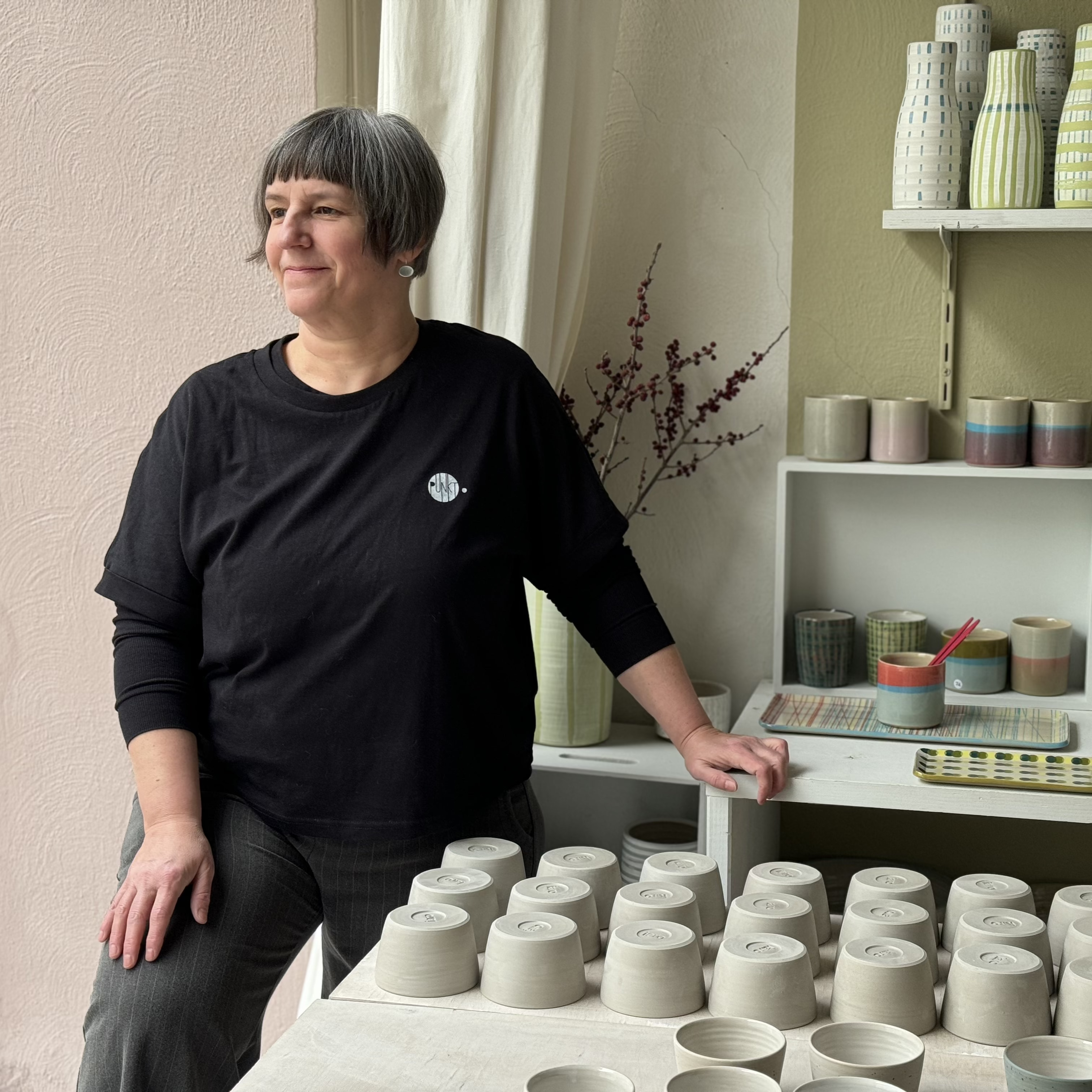 The Artist Jutta Becker is standing in her atelier in Karlsruhe Suedstadt surrounded by her handmade ceramic cups and vases.