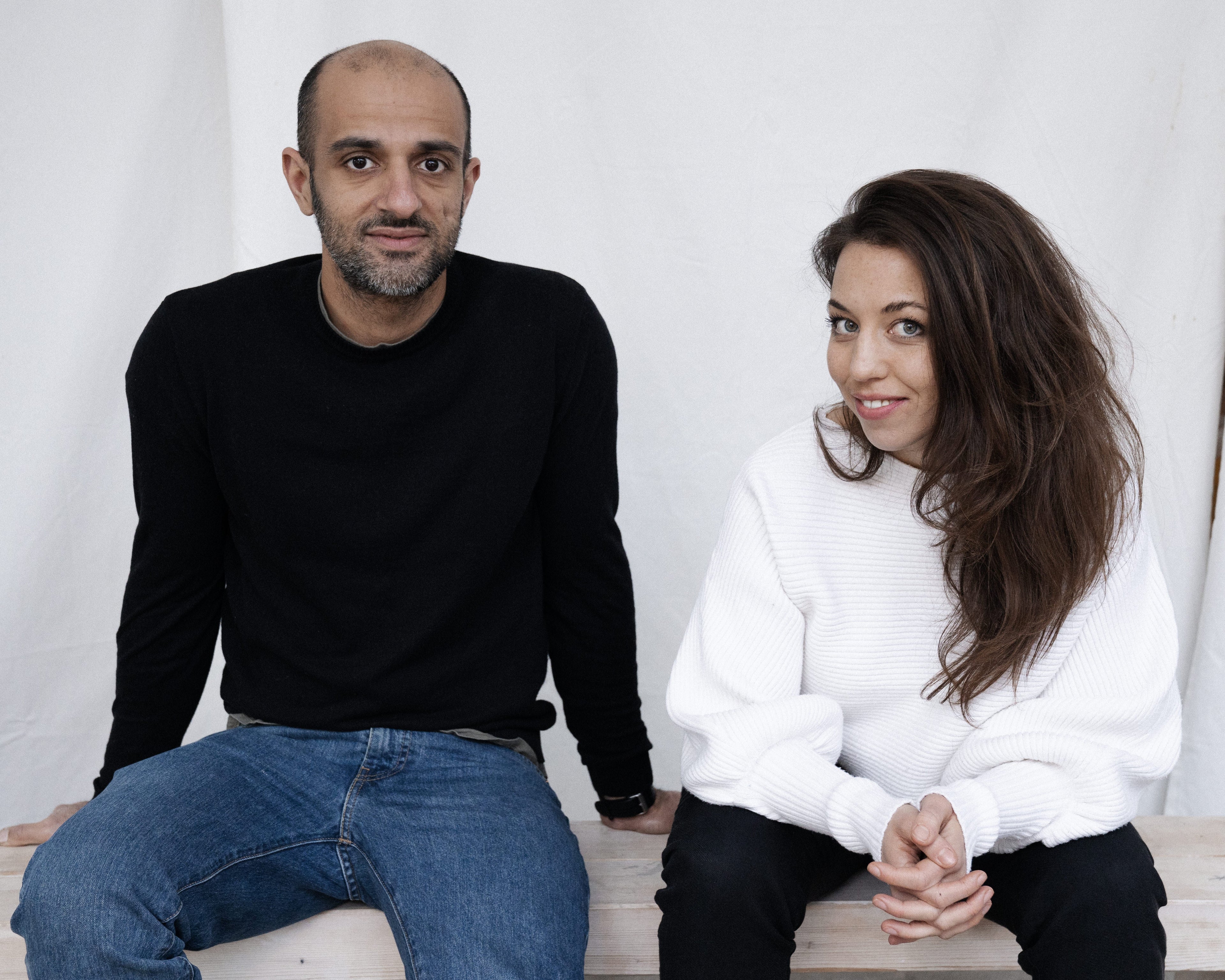 The founders of the iaro specialty coffee brand are sitting next to each other on a wooden bench.