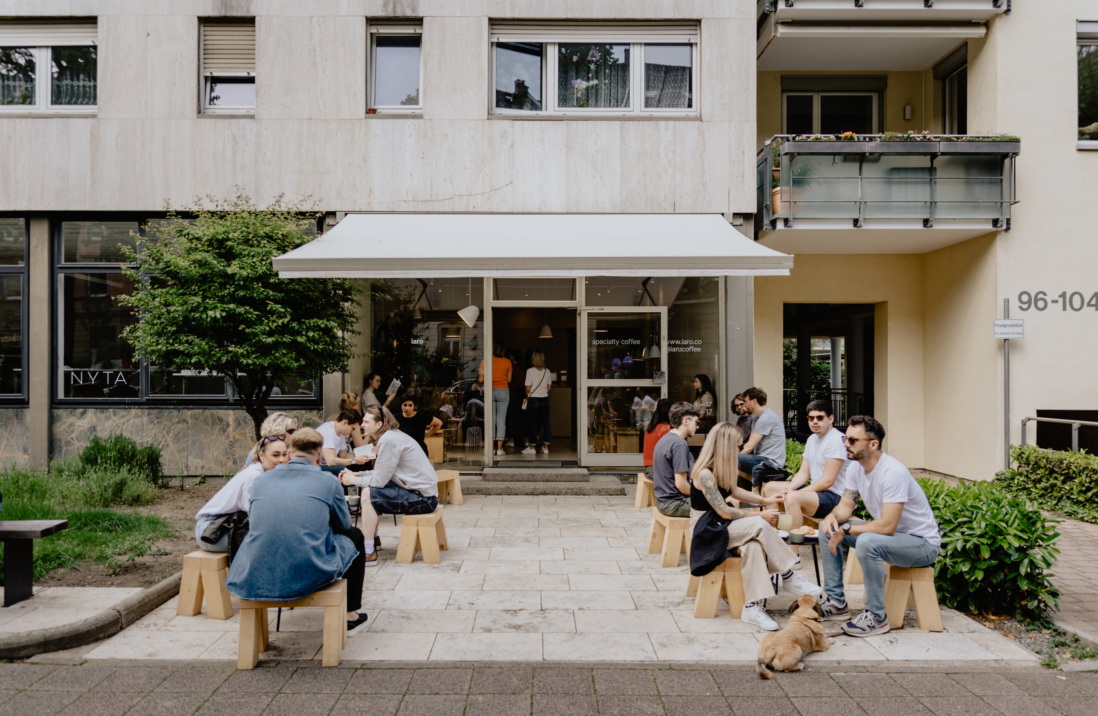 terrace of coffee shop full of people drinking coffee