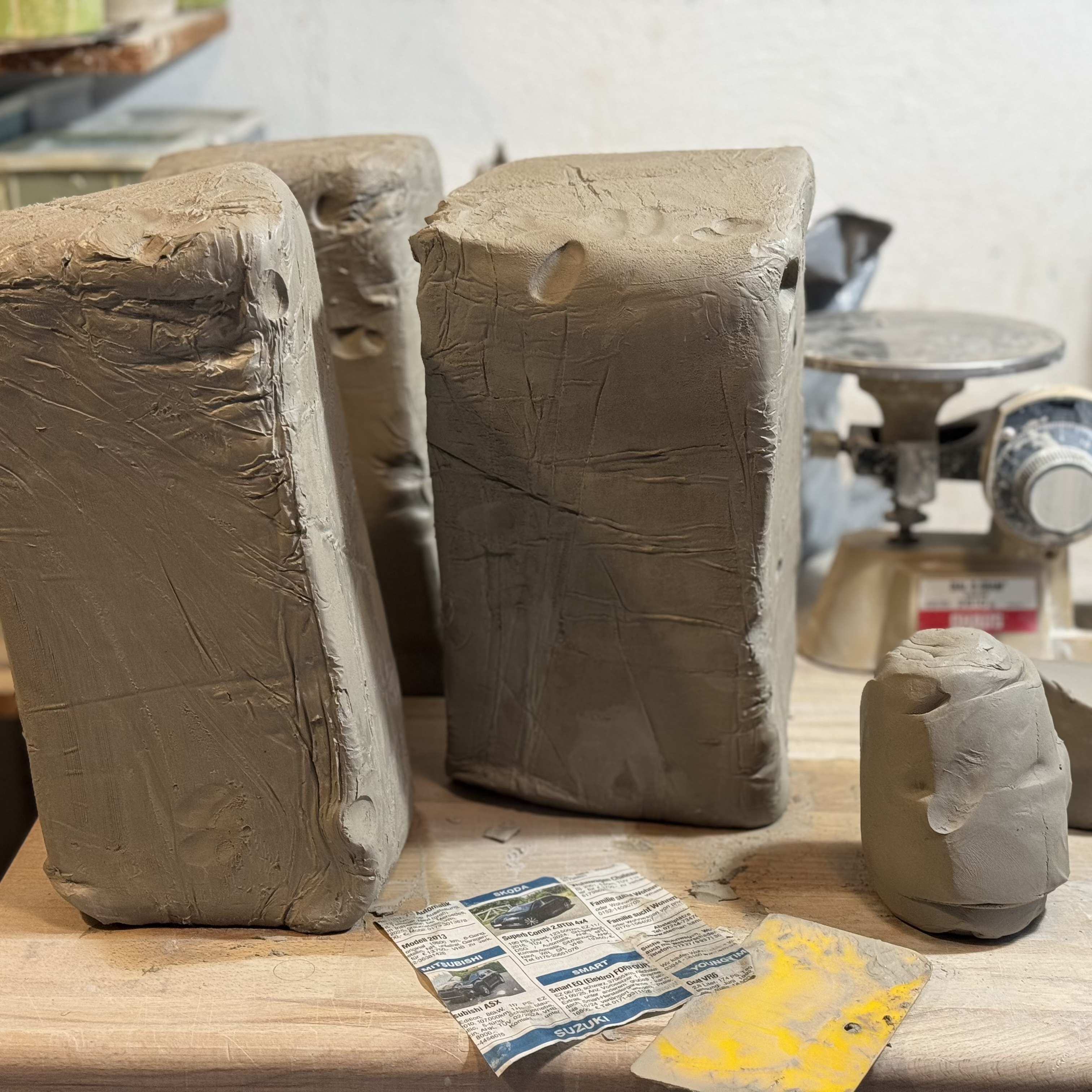 Piles of soft clay standing next to a mechanical scale.