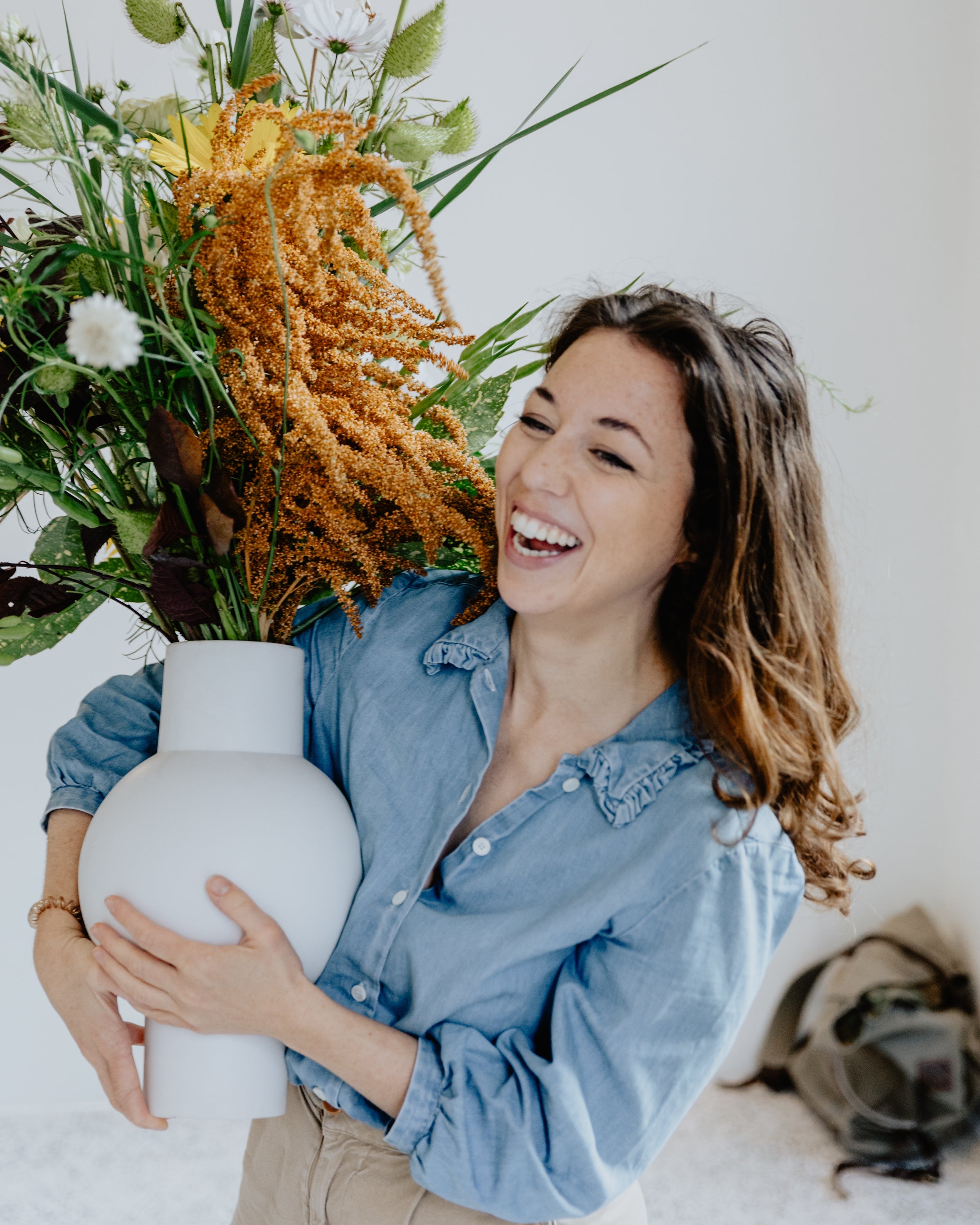 The co-founder of the specialty coffee brand iaro is portrayed holding a boquet of flowers at the opening of the second coffeeshop.